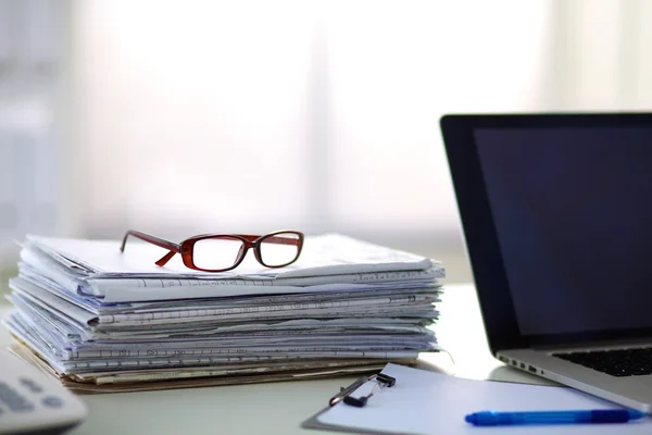 Ordinateur portable avec pile de dossiers sur la table sur fond blanc — Photo