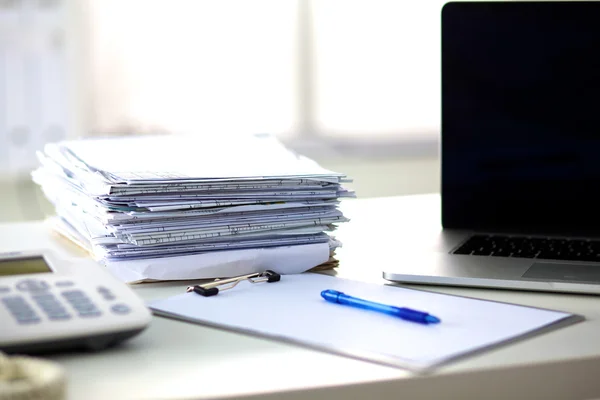 Laptop met stapel mappen op tafel op witte achtergrond — Stockfoto