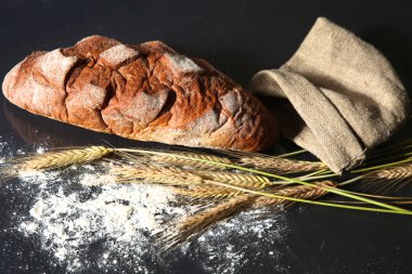 rustik kaşarlı ekmek ve buğday kulaklara koyu ahşap bir masa