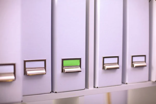 Many papers orderly arranged in a file shelves. And some are still on the table