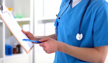 Kadın doktor hastaya danışmanlık yaparken başvuru formu tutuyor