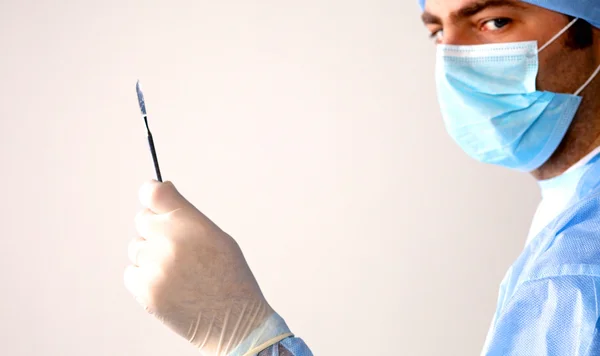 Man chirurg houdt een scalpel in een operatiekamer — Stockfoto