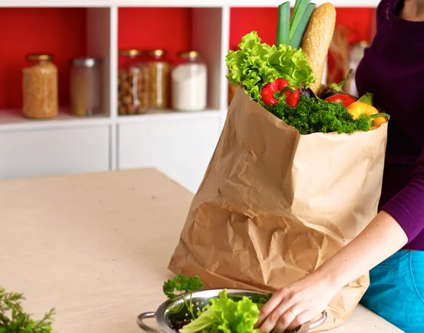 Healthy positive happy woman holding a paper shopping bag full of fruit and vegetables