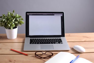 Laptop ahşap bir masada duruyor.