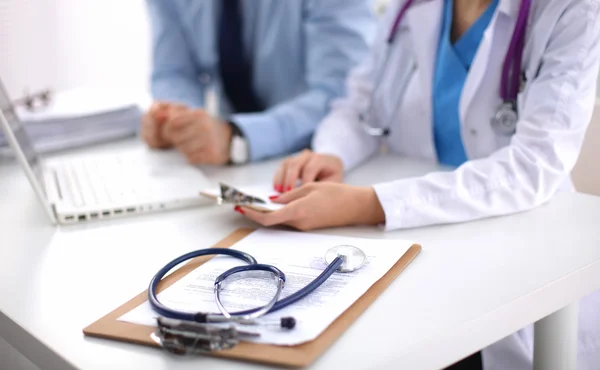 Erkek ve kadın doktorlar sağlık raporlarında üzerinde çalışıyor