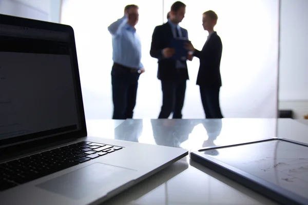 Focus op laptop op de tafel. Wazig mensen op achtergrond — Stockfoto