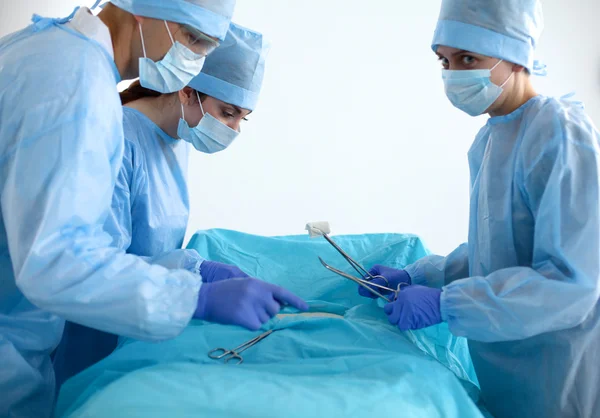 Equipe de cirurgião em uniforme realizar operação em um paciente na clínica de cirurgia cardíaca — Fotografia de Stock