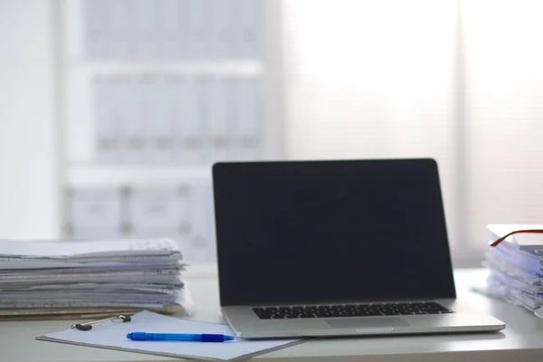 Laptop met stapel mappen op tafel op witte achtergrond — Stockfoto