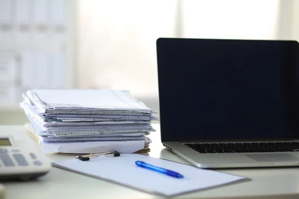 Ordinateur portable avec pile de dossiers sur la table sur fond blanc — Photo