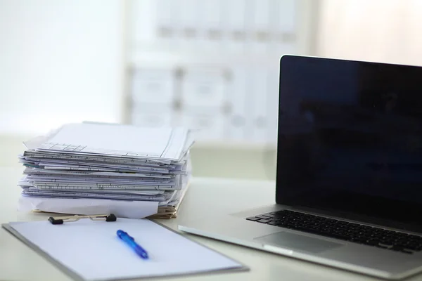 Laptop mit Ordnerstapel auf Tisch auf weißem Hintergrund — Stockfoto