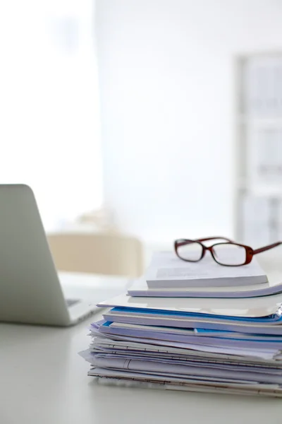 Beyaz arkaplanda dizin yığını olan dizüstü bilgisayar