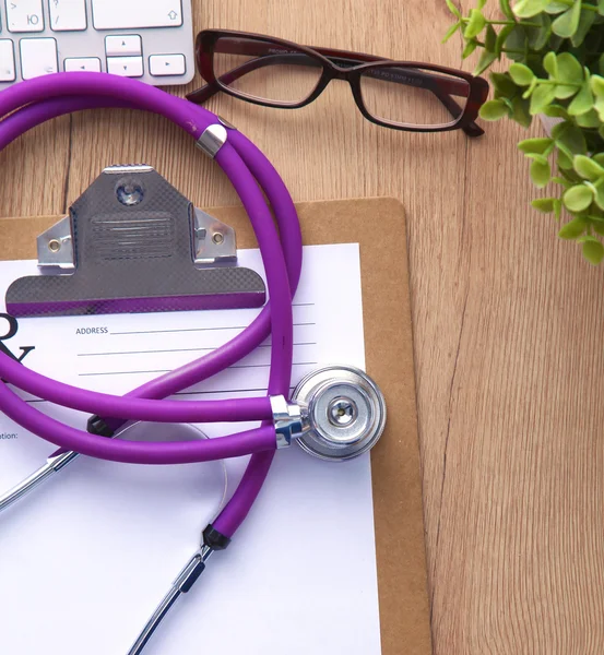 A medical stethoscope near a laptop on a wooden table, on white — Stock Photo, Image