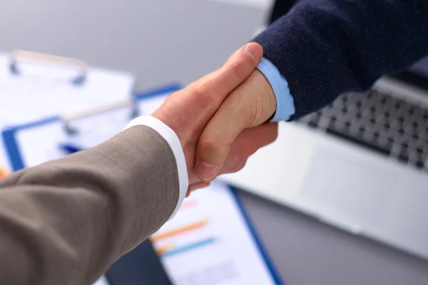 Business handshake. Two businessman shaking hands with each other in the office