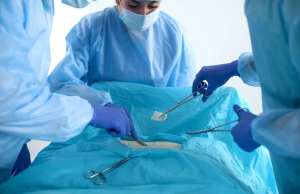 Equipe de cirurgião em uniforme realizar operação em um paciente na clínica de cirurgia cardíaca — Fotografia de Stock