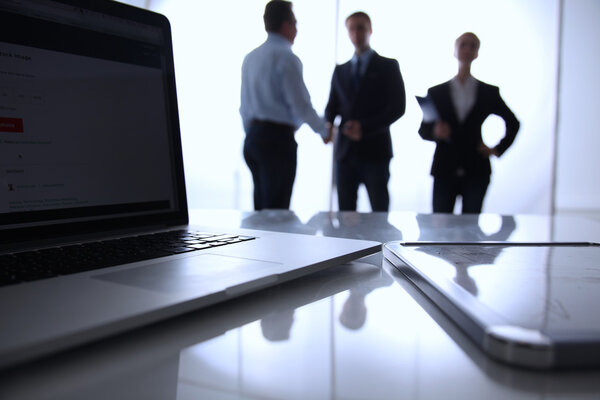 Сосредоточься на ноутбуке. Размытые люди на заднем плане
