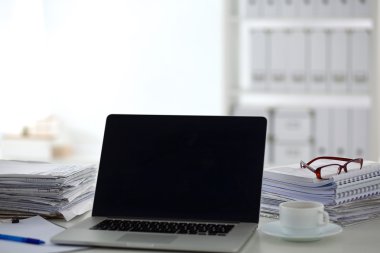 Beyaz arkaplanda dizin yığını olan dizüstü bilgisayar