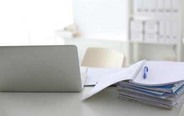 Beyaz arkaplanda dizin yığını olan dizüstü bilgisayar