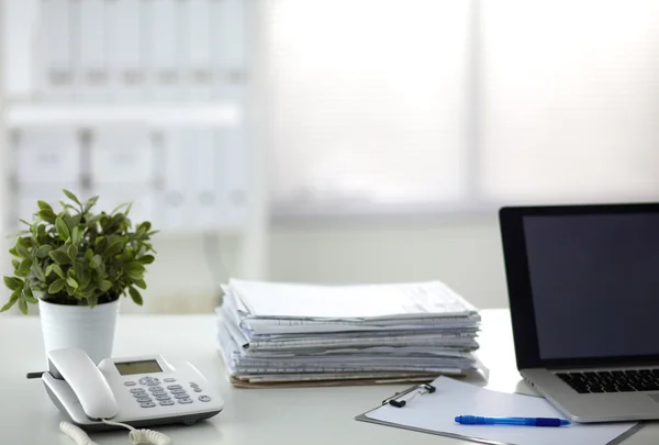 Laptop mit Ordnerstapel auf Tisch auf weißem Hintergrund — Stockfoto