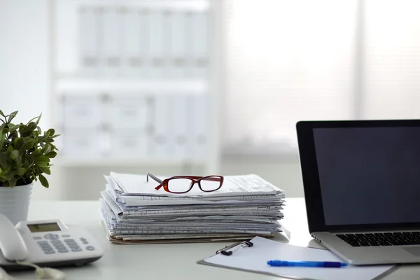 Beyaz arkaplanda dizin yığını olan dizüstü bilgisayar