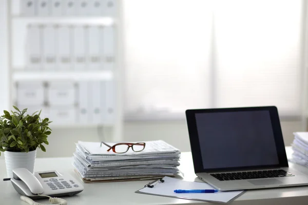 Laptop com pilha de pastas na mesa sobre fundo branco — Fotografia de Stock