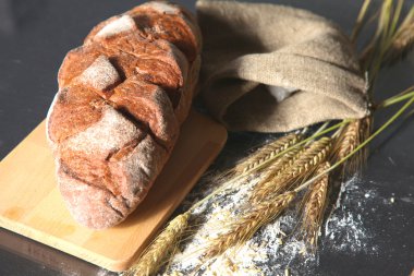 rustik kaşarlı ekmek ve buğday kulaklara koyu ahşap bir masa