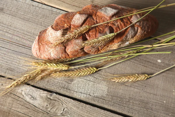 Freshly baked traditional bread on wooden table — Stock Photo, Image