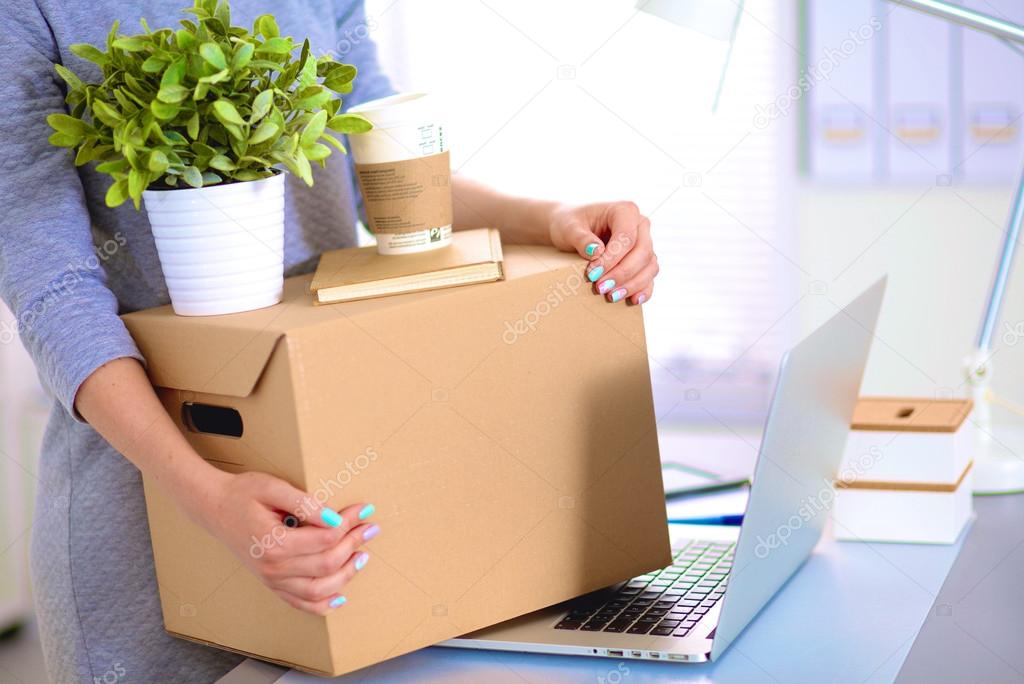 Happy team of businesspeople moving office, packing boxes, smiling