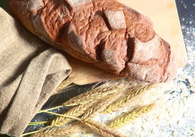 rustik kaşarlı ekmek ve buğday kulaklara koyu ahşap bir masa