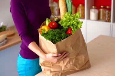 meyve ve sebze dolu alışveriş kese kağıdı tutan pozitif sağlıklı mutlu kadın