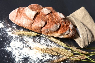 rustik kaşarlı ekmek ve buğday kulaklara koyu ahşap bir masa