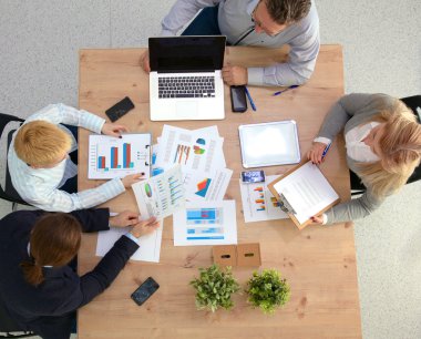 İş ortaklarının toplantıda belge ve fikirleri tartıştığı resim