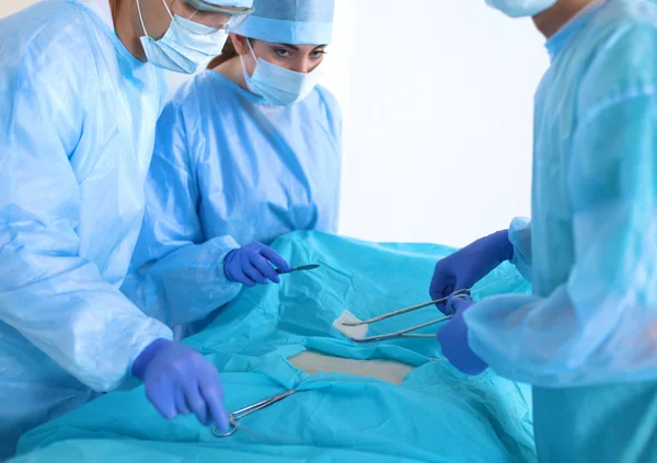 Equipe de cirurgião em uniforme realizar operação em um paciente na clínica de cirurgia cardíaca — Fotografia de Stock