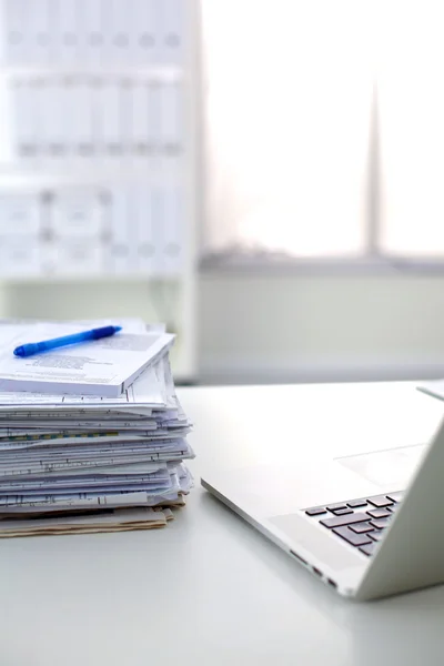 Beyaz arkaplanda dizin yığını olan dizüstü bilgisayar