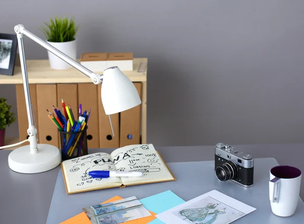 Дизайнерский стол с ним, лежащий на инструментах и камере — стоковое фото