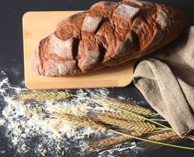 rustik kaşarlı ekmek ve buğday kulaklara koyu ahşap bir masa