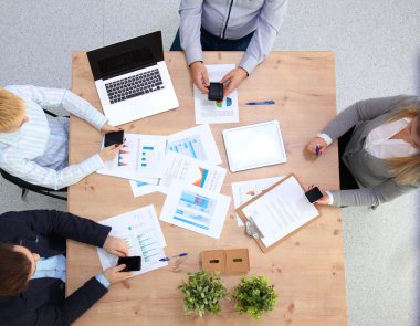 İş ortaklarının toplantıda belge ve fikirleri tartıştığı resim