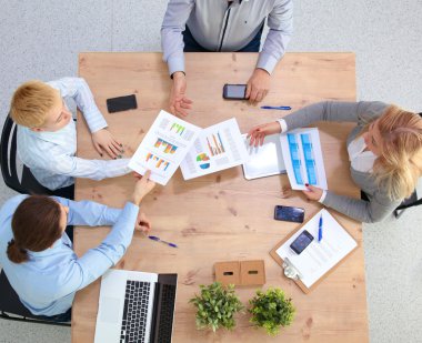 İş ortaklarının toplantıda belge ve fikirleri tartıştığı resim