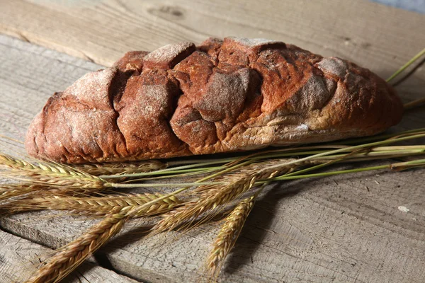 Freshly baked traditional bread on wooden table — Stock Photo, Image