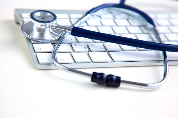 A medical stethoscope near a laptop on a wooden table, on white