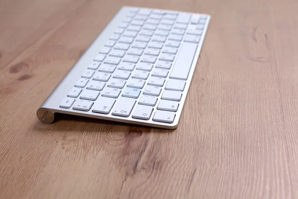 木製のテーブルに横になっているコンピューターのキーボード — ストック写真