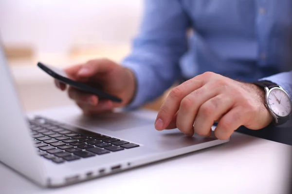 Geschäftsmann am Tisch mit Smartphone und Laptop — Stockfoto