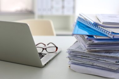 Stack of papers and glasses lying on table desaturated clipart
