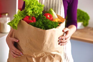 Mutfakta sebze doğrayan genç bir kadın.