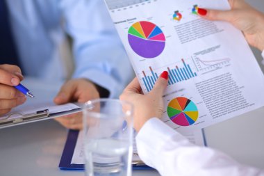 İş ortaklarının toplantıda belge ve fikirleri tartıştığı resim