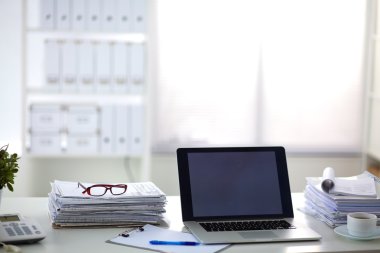Beyaz arkaplanda dizin yığını olan dizüstü bilgisayar
