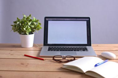 Laptop ahşap bir masada duruyor.
