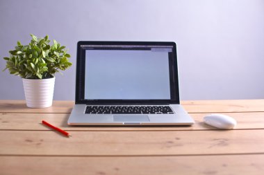 Laptop ahşap bir masada duruyor.