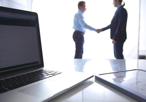 Сосредоточься на ноутбуке. Размытые люди на заднем плане
