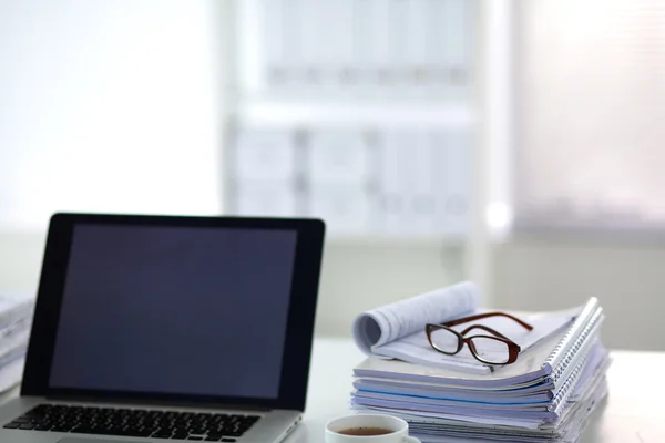 Laptop com pilha de pastas na mesa sobre fundo branco — Fotografia de Stock