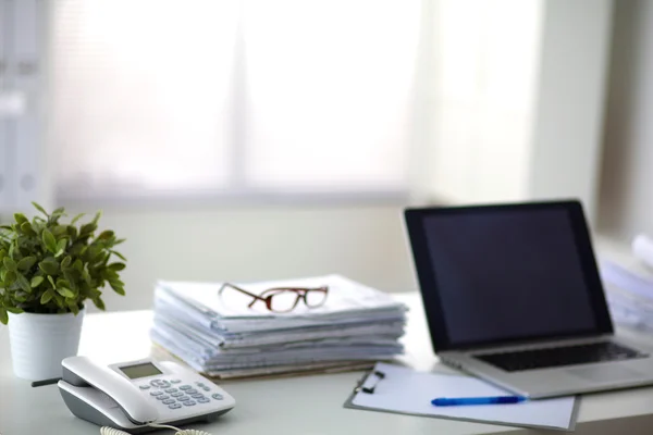 Laptop mit Ordnerstapel auf Tisch auf weißem Hintergrund — Stockfoto